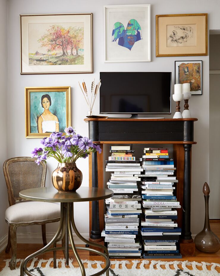 Here the TV fits right in among the artworks. The stacks of books below also help to make it feel like just one more element in a tableau rather than the dominant feature. Find the framed Modigliani print, Christine (at lower left in the gallery wall), here.
